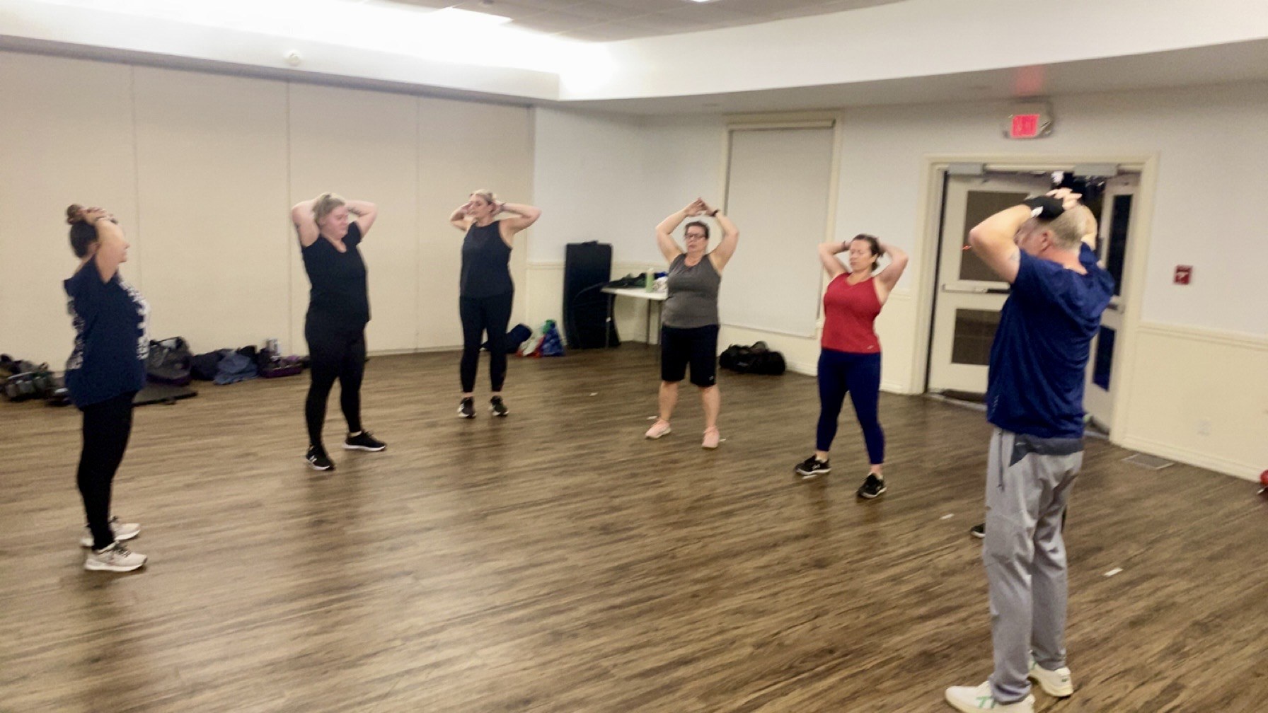 Adult participants pausing together during a structured movement and recovery exercise